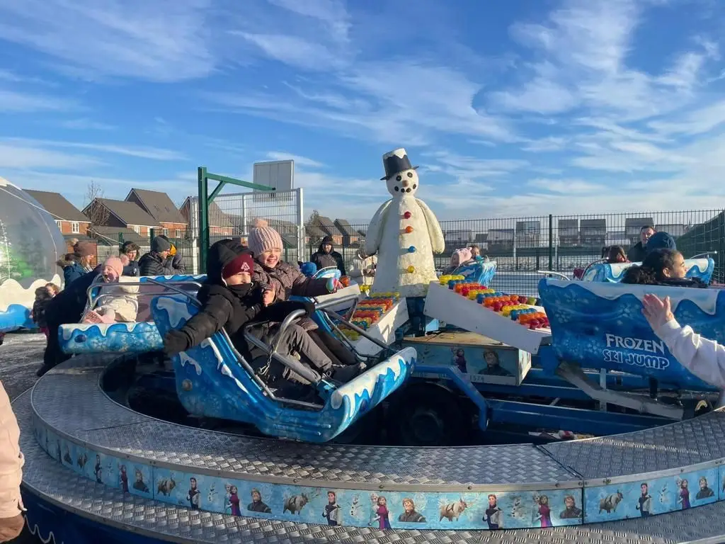 People having fun at ride in Christmas market