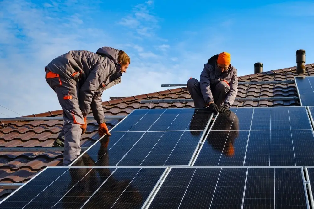 Two men installing solar panels