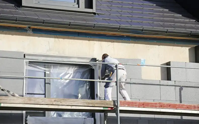 Builder working on external wall insulation.