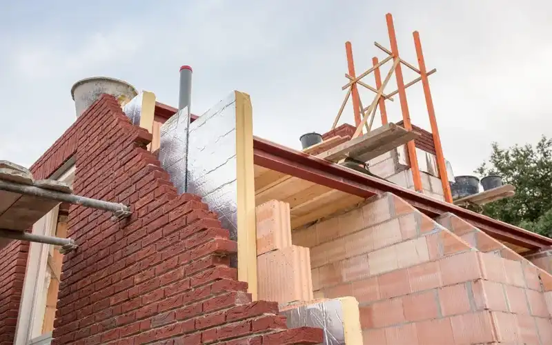 Cavity wall insulation being installed.